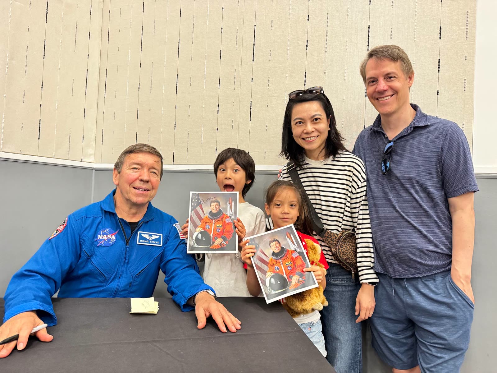 Dr. Tao with her family and NASA astronaut Michael Barratt, the children holding signed astronaut photos